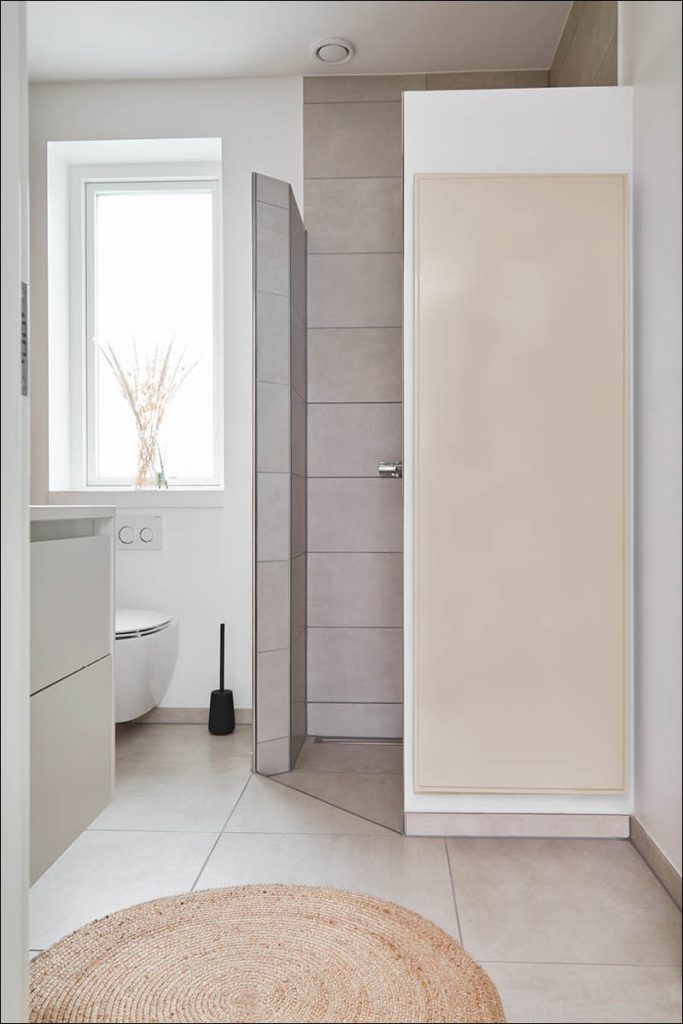 A painted vertical radiator placed in a bathroom setting