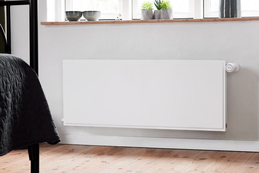 A white Hudevad Plan Horizontal radiator in bedroom